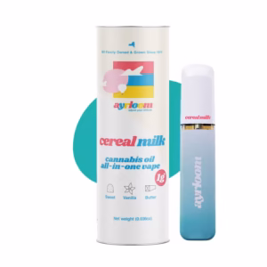 A white Ayrloom Cereal Milk cannabis oil pen packaging tube resting diagonally inside a bright yellow bowl filled with colorful looped cereal, set on a pastel checkered surface.